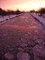 Sonnenaufgang über dem vereisten Kanal
