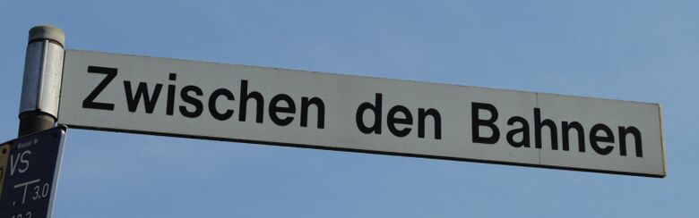 Straßenschild Zwischen den Bahnen